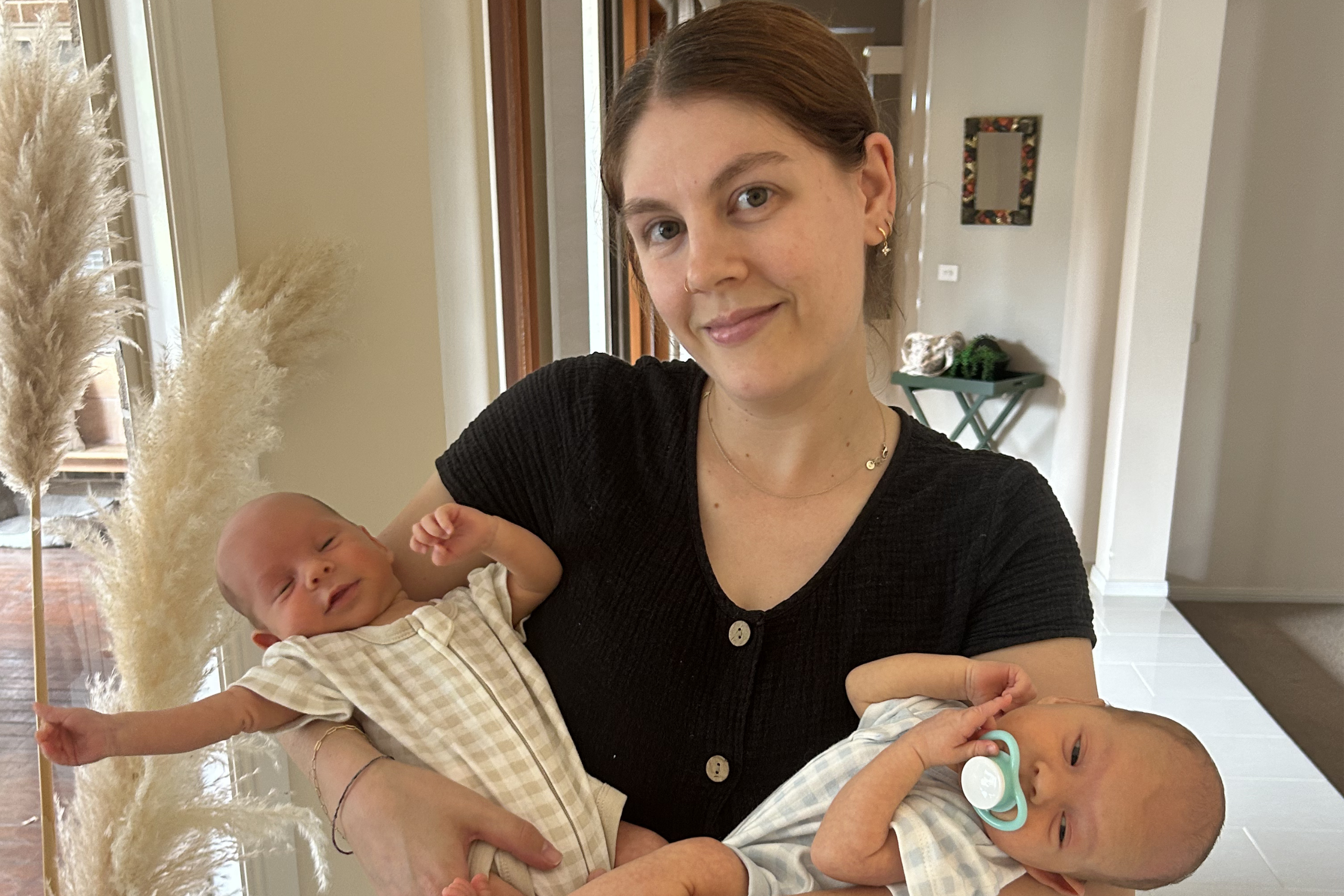 Young woman holding two newborn babies
